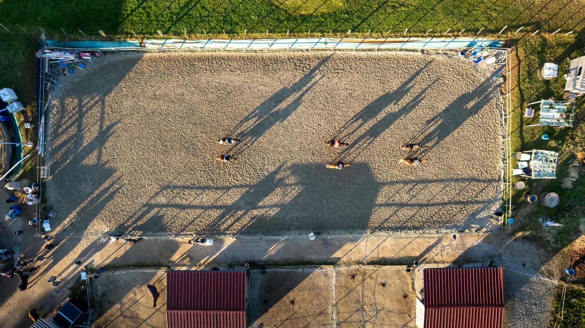 Aerial view of the yard’s arena, with a group of riders in a session