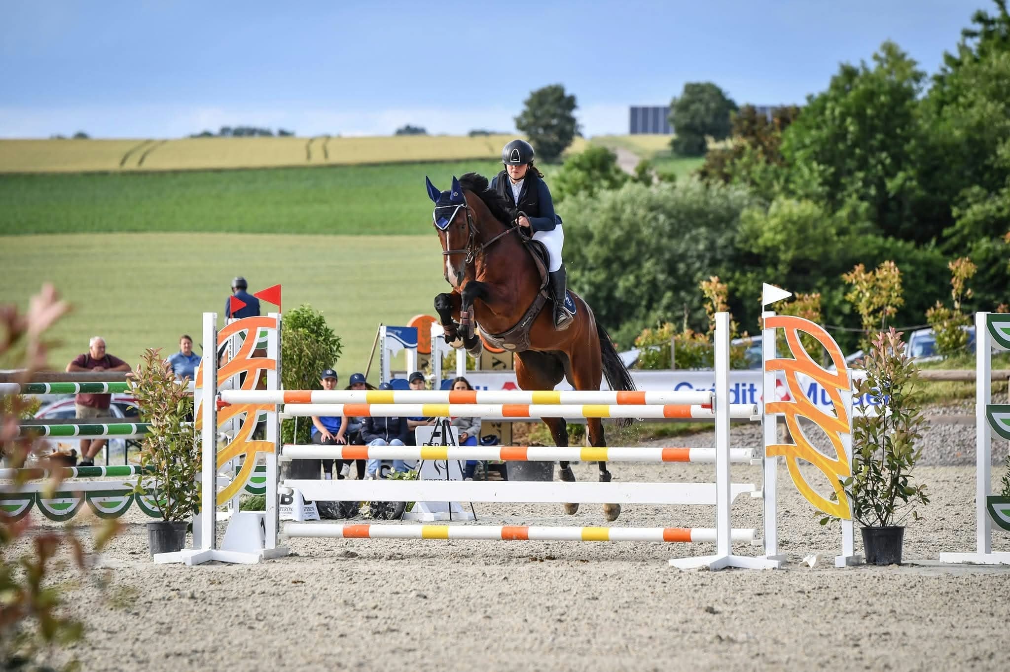 Laura Jardon, the instructor, jumping a fence with her horse at a show jumping competition